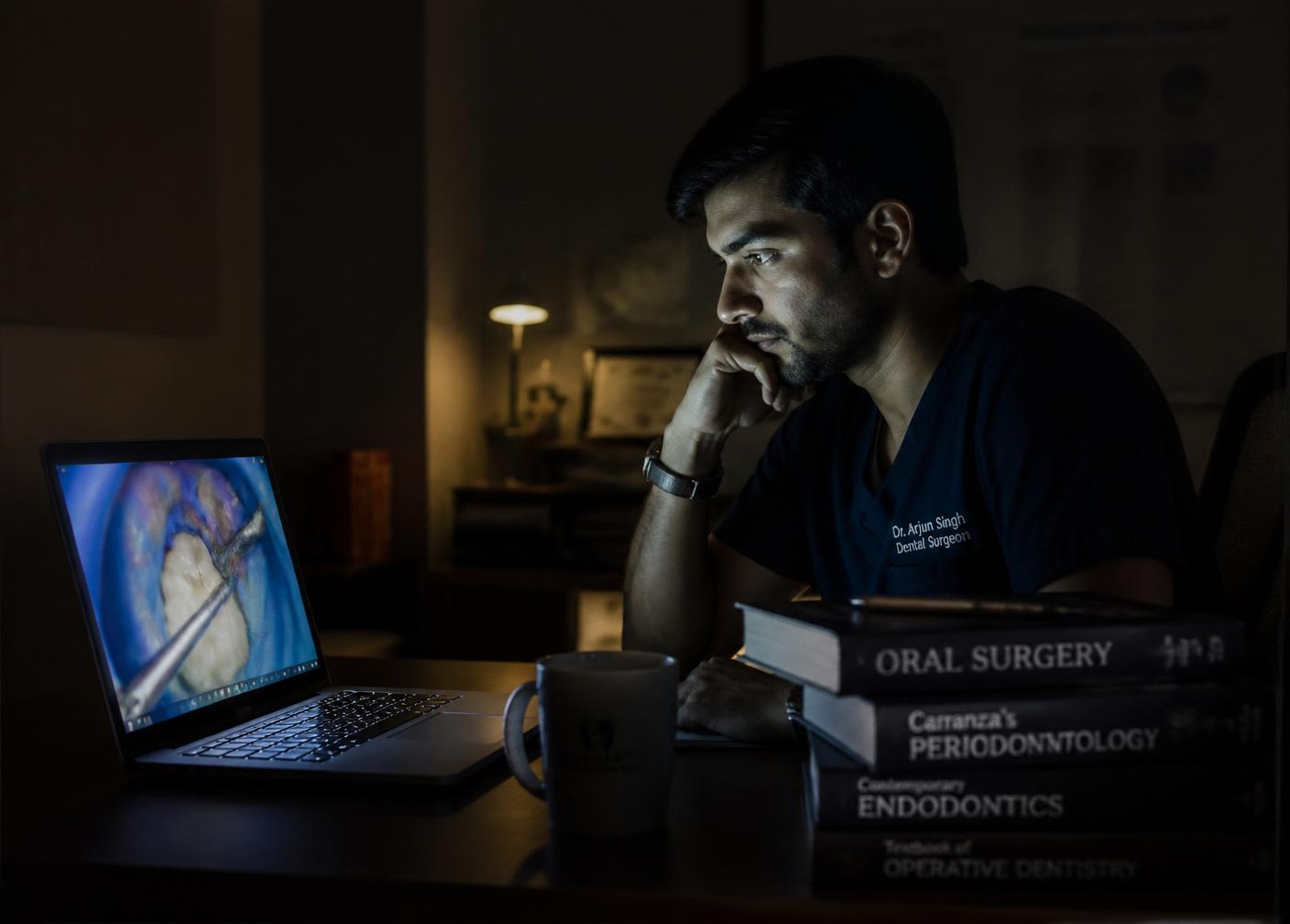 Clinician studying late at night looking at laptop screen tutorial
